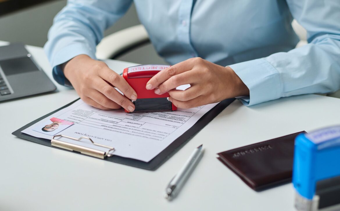 Specialist of visa center putting stamp on document